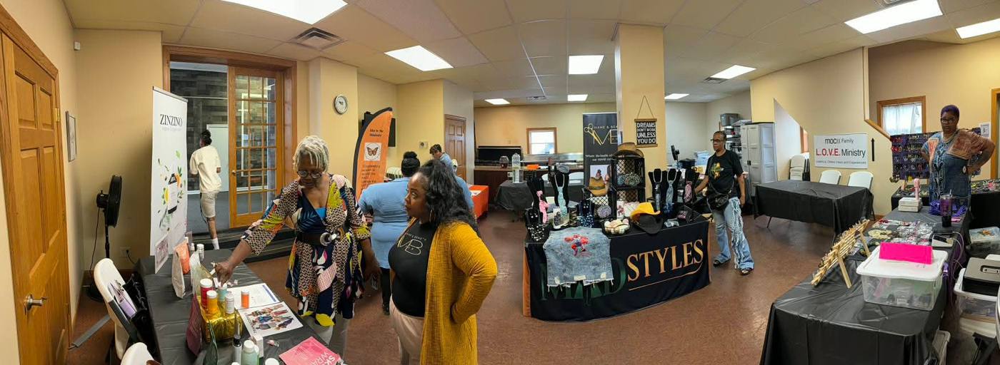 Panoramic view of vendors and attendees mingling in the marketplace.