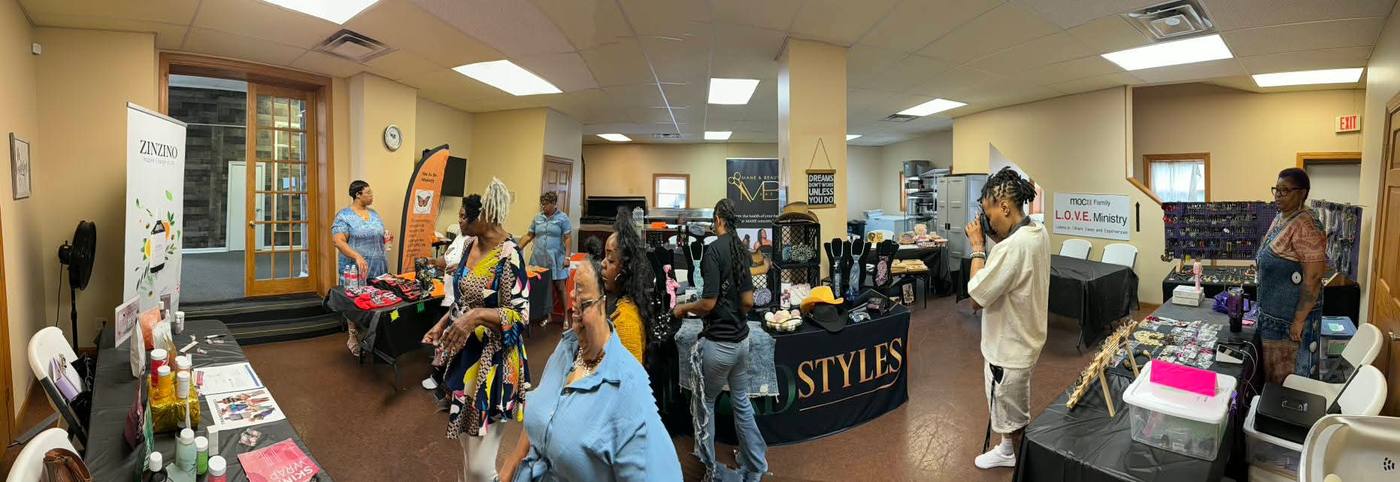 Wide view of the Breaking Bread & Chains marketplace with attendees browsing vendor tables.