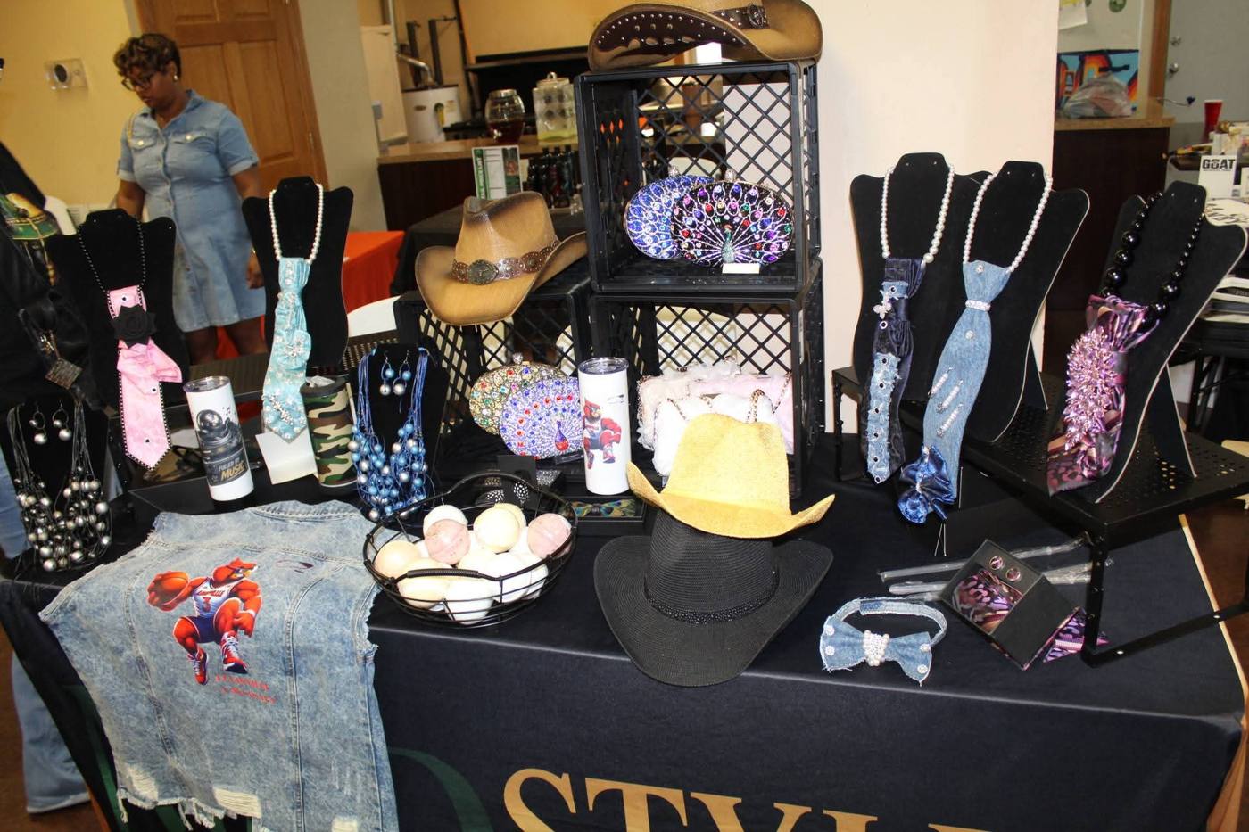 MAD Styles vendor table with jewelry, hats, and accessories.